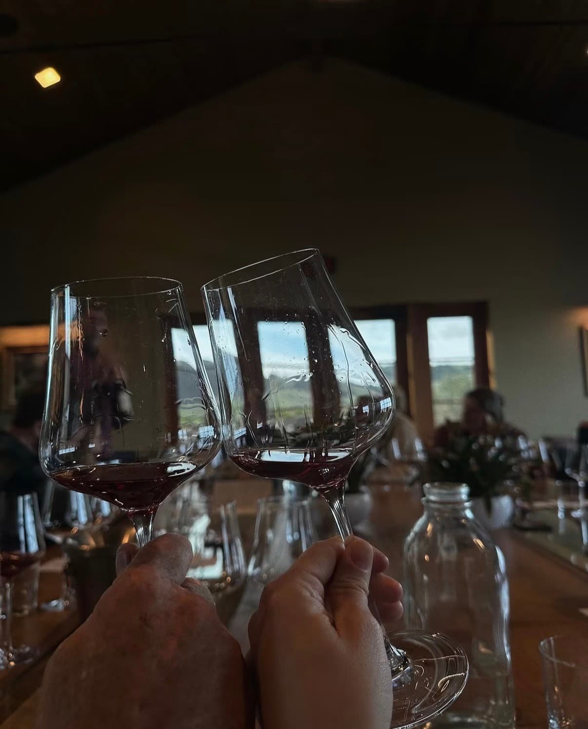 Two glasses of red wine raised in a winery tasting room