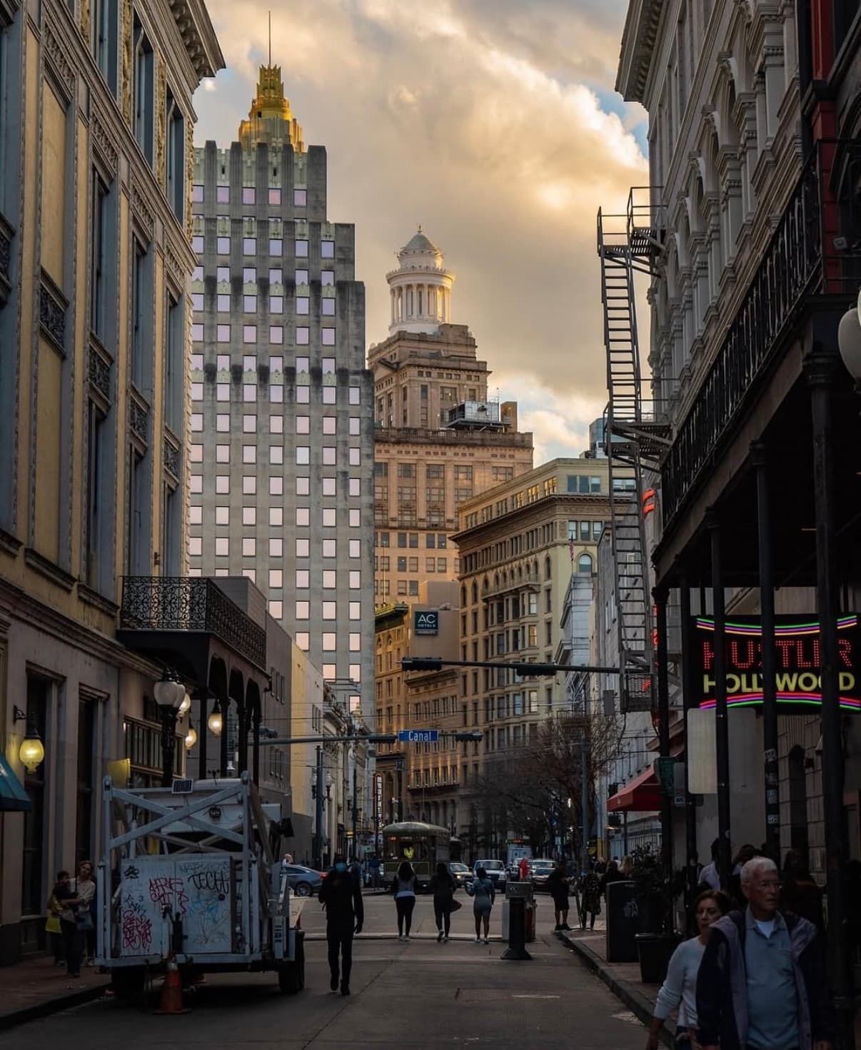 A busy downtown New Orleans street below Art Deco towers