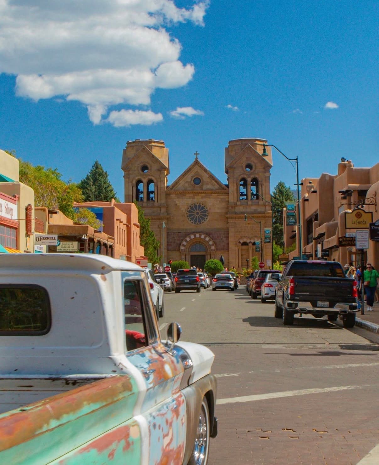 A Santa Fe street leading to the Cathedral Basilica, with a vintage truck in front