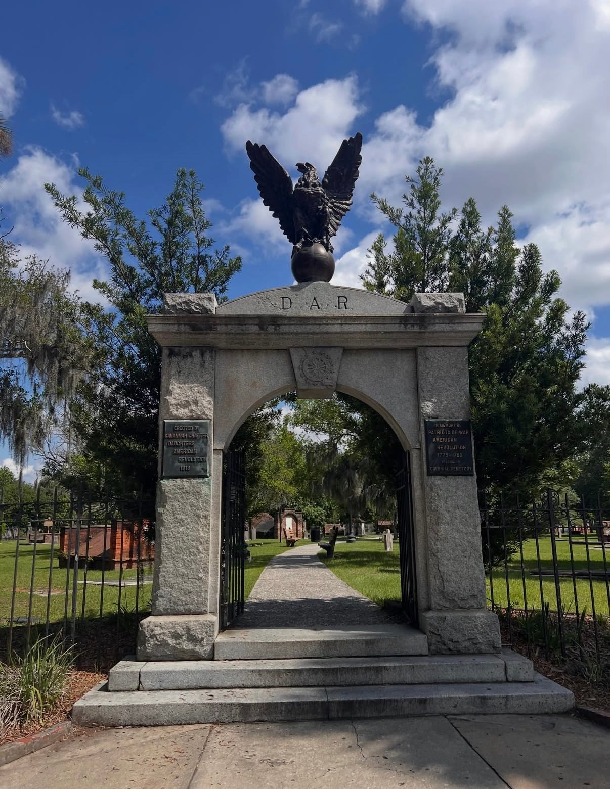 A stone memorial arch topped by an eagle in a Savannah park