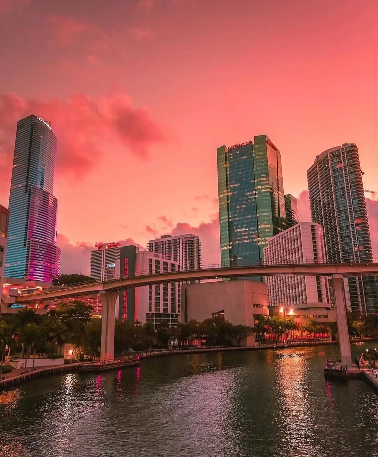 Miami towers and the Metromover above the river at a pink dusk