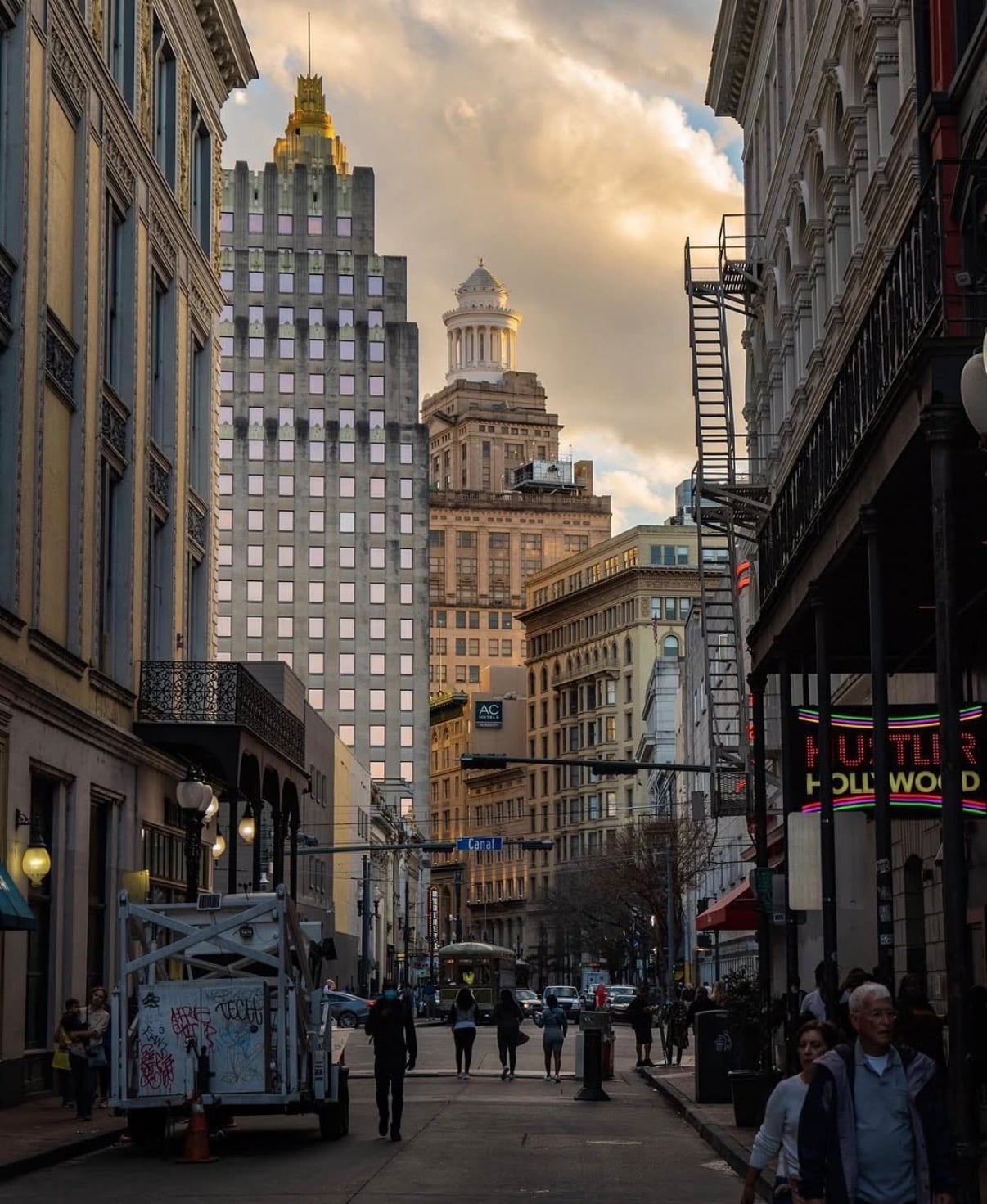 A busy downtown New Orleans street below Art Deco towers