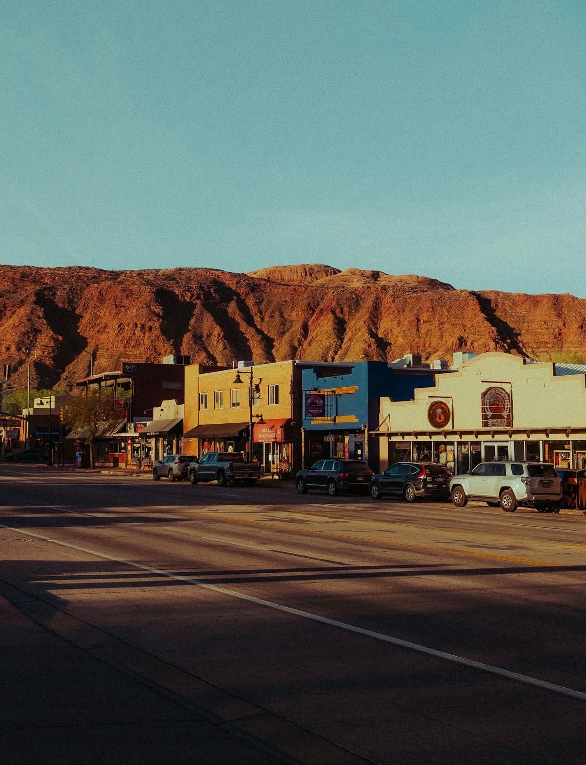 Moab's main street with shopfronts below the red cliffs