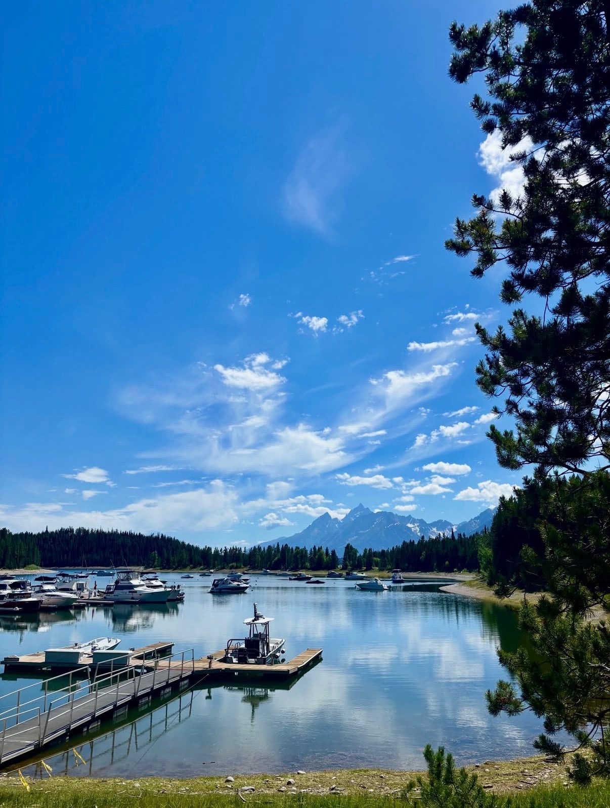 Boats at a lakeside marina with jagged peaks on the horizon