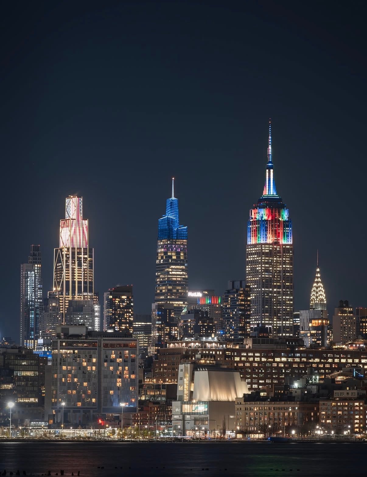 Midtown's towers lit red, white and blue at night across the river